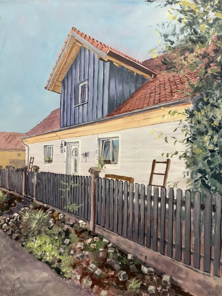 Das Bild von der ukrainischen Künstlerin Maryna Khrystenko ein idyllisches weißes Haus mit Holzgaube und hölzernem Gartenzaun.